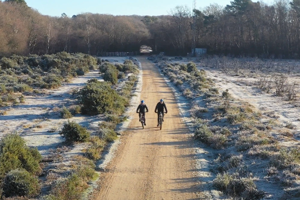 Two people cycling on an icy day in the countryside