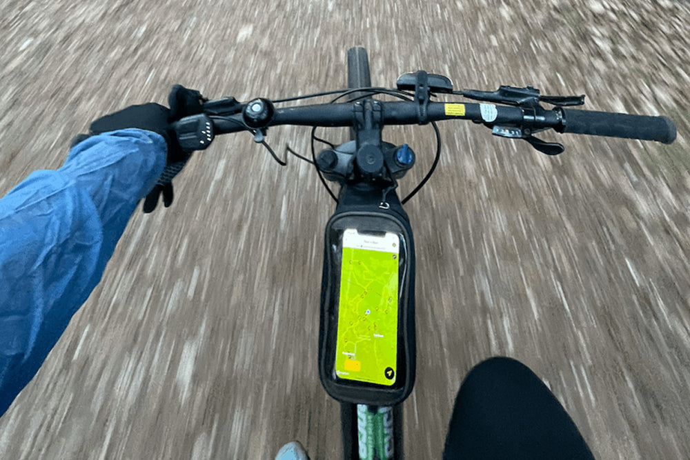 Image of handlebars on a bike in motion showing a mounted phone with map