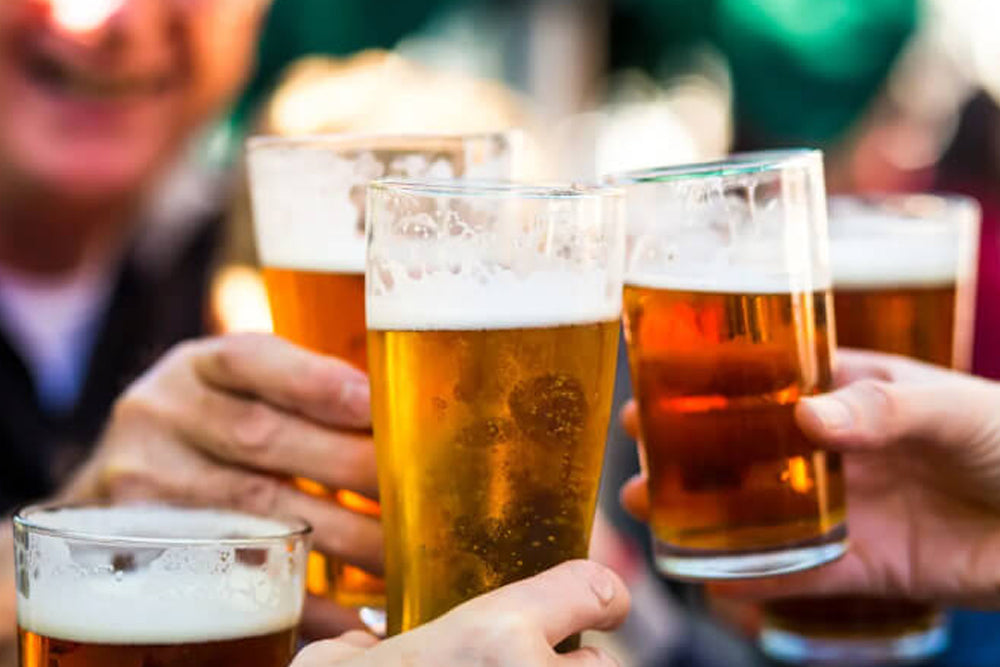 People holding glasses of beer in a social setting