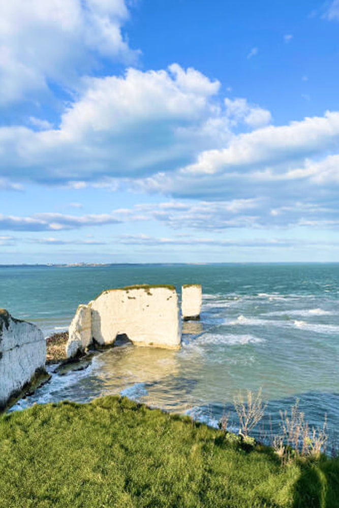 White cliffs by the sea under a blue sky with clouds