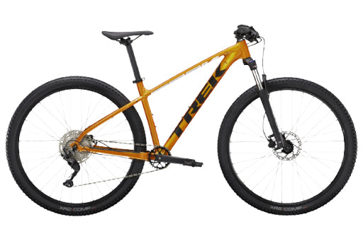A Trek full-suspension mountain bike in a metallic orange frame with black components, shown from a side profile on a white background.