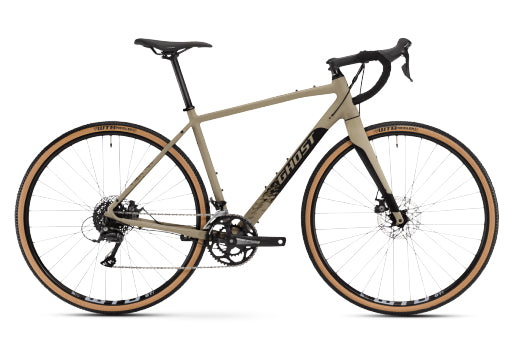 A Ghost road/gravel bicycle in a sand-colored frame with black components, drop handlebars, and tan sidewall tires, shown from a side profile on a white background.