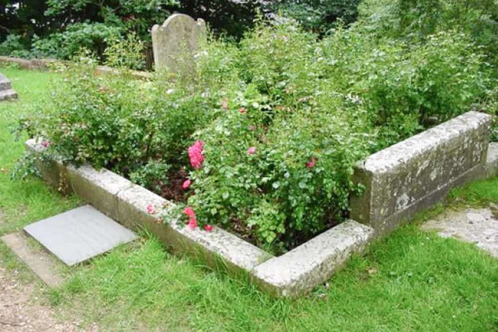 A gravestone with plants and flowers