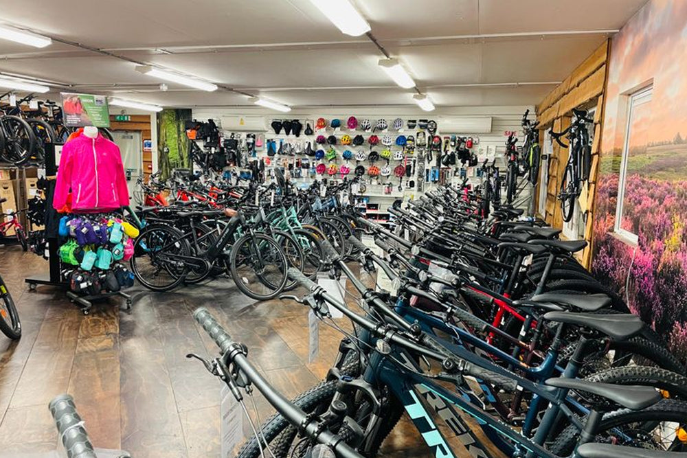 Bicycle store interior with various bicycles and accessories on display.
