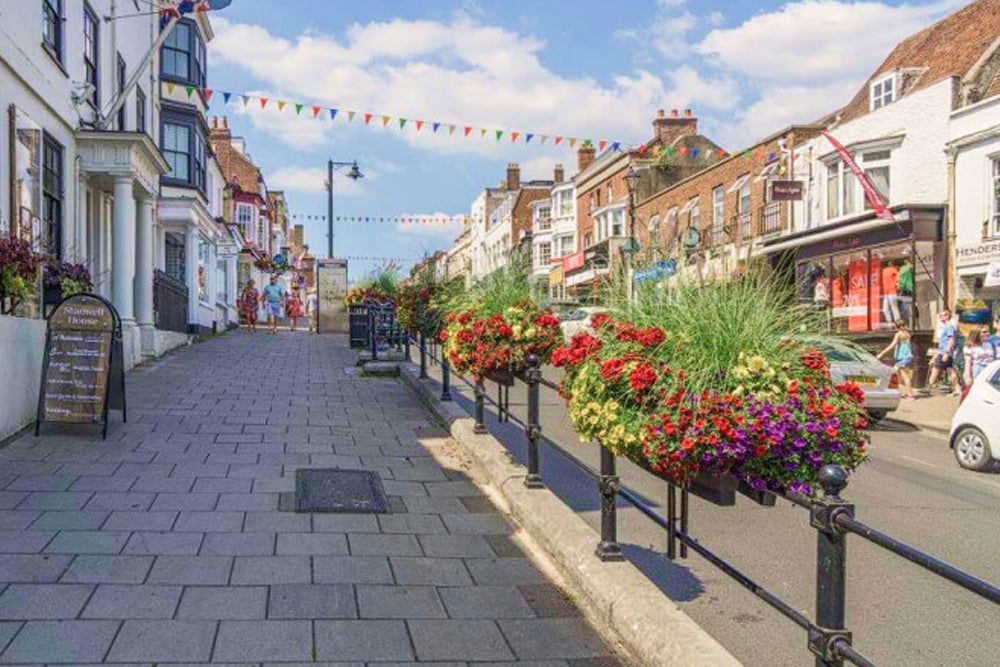 Tiled street with flower baskets and shops on a sunny day
