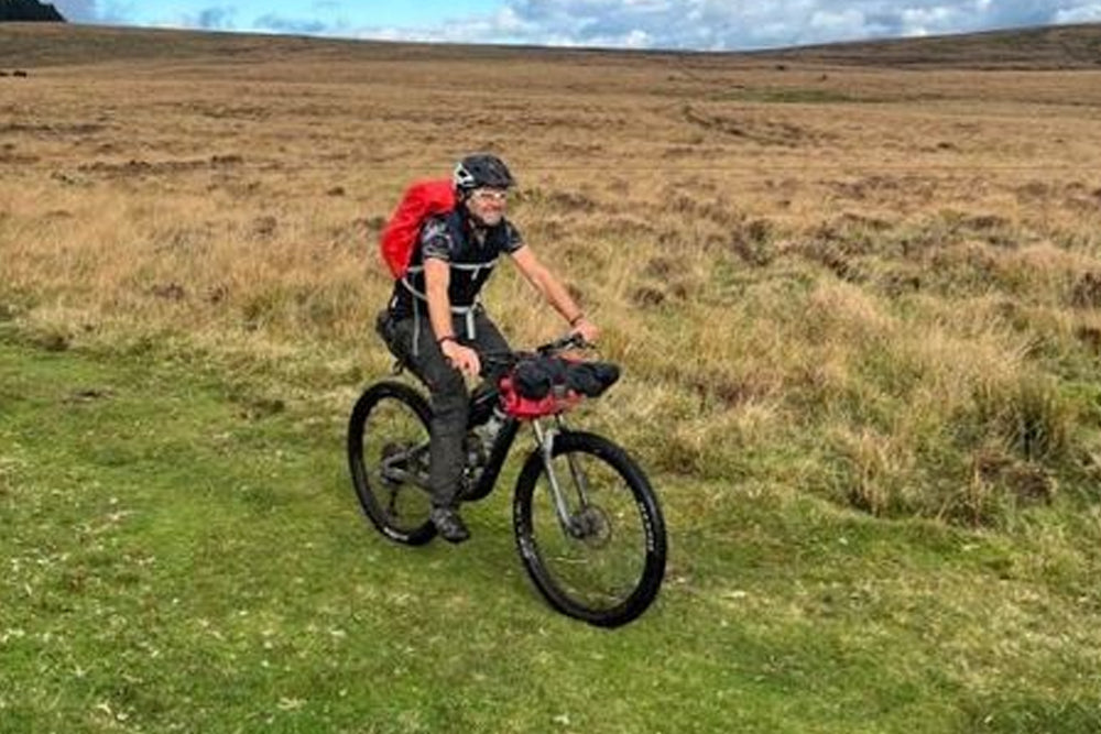 Man riding a bike on scenic moorland