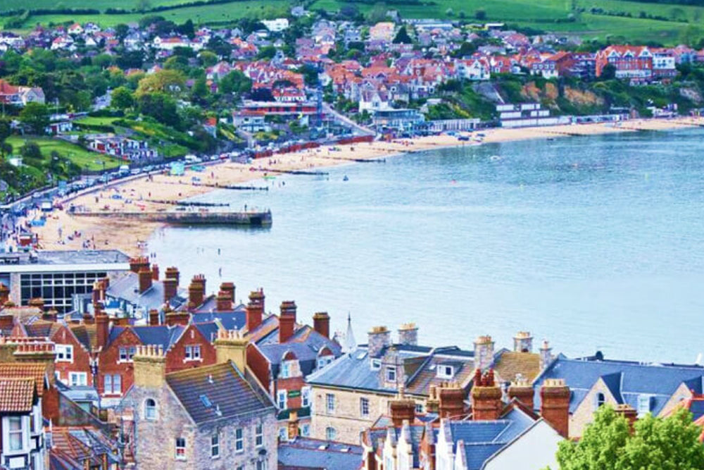 Town by the sea with colorful rooftops and a clear blue sky