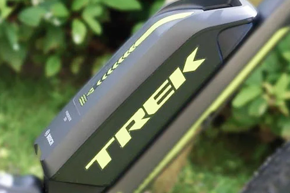 Close-up of a Trek bicycle frame with greenery in the background