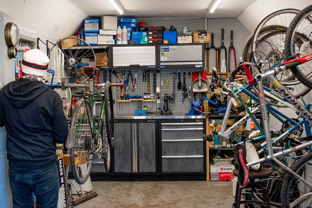 Person in a garage with bicycles and tool storage